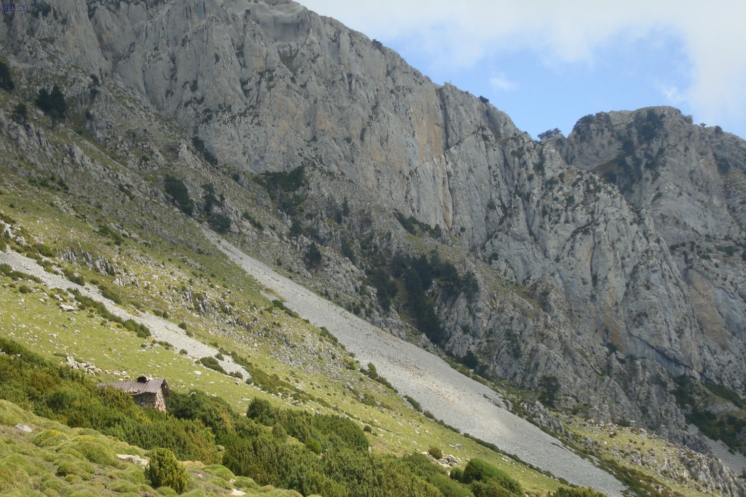 A la izquierda pequeña cabaña de pastores con fuente de agua.