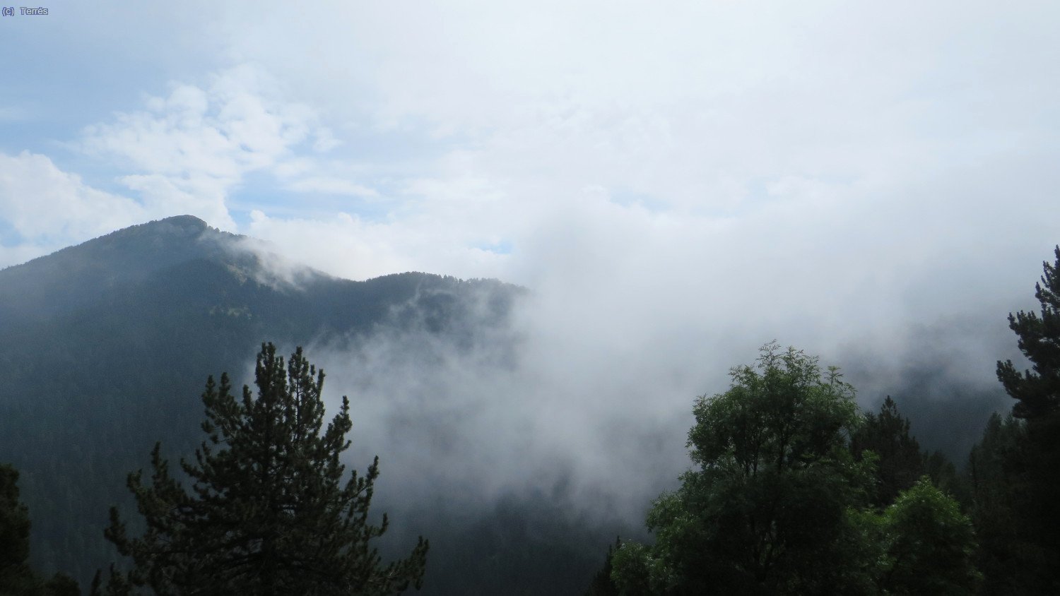 Desde las inmediaciones del Roc Cremat, vistas hacía el las Penyes Altes de Moixeró a la izqueirda y el Coll de Moixeró entre la niebla