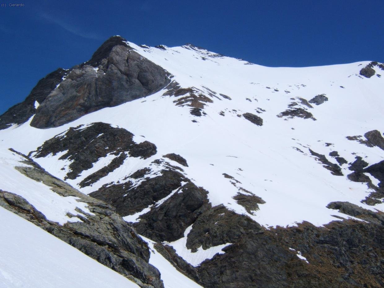 Y el mismo flanco desde media bajada. La ruta va ascendiendo de izquierda a derecha (desde el collado de las Puertas) y luego remonta recto hasta la antecima sur, la puntita rocosa arriba de todo.