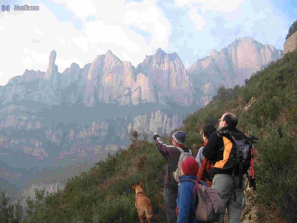 el grupo mirando la cara norte del macizo. Pues si que nos queda hasta la cima... hasta la perra está atenta a las explicaciones del guía Jordi...