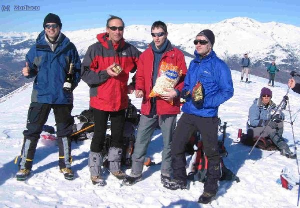 Eduard con el cava, Jam con los Ferrero Rocher, Zodiaco con las palomitas, y Waldo con los minitoblerones, en la cima del Taga. Nicky almorzando junto al termo de infusión, y el trípode de Javier
