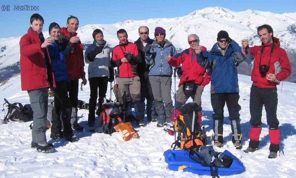 Zodiac, Waldo, Jam, Kris, Jordi C, Pratenc, Nicky, Tonimd, Esunyen y Octane brindando con cava en la cima del Taga, con el Puigmal como telón de fondo.