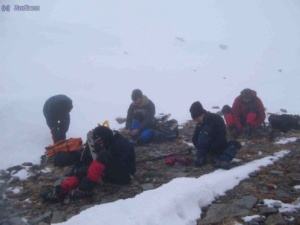 calz&aacute;ndose los crampones para empezar el descenso