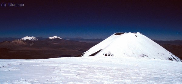 Cuatro seismiles en la misma foto: Detrás Acotango y Guallatiri y Parinacota en plano medio desde la cima del Pomerape