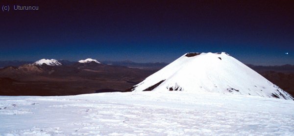 Cuatro seismiles en la misma foto: Detr&aacute;s Acotango y Guallatiri y Parinacota en plano medio desde la cima del Pomerape