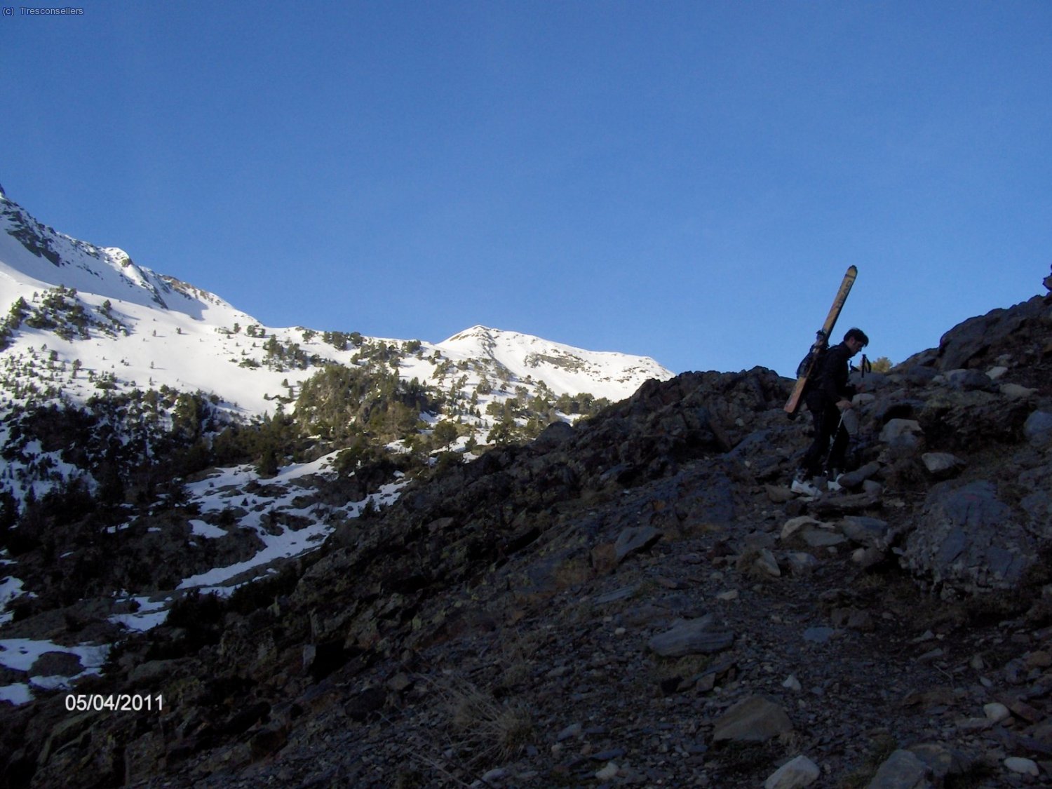 Porteando los esqu&iacute;s, buscando la nieve del fondo.
