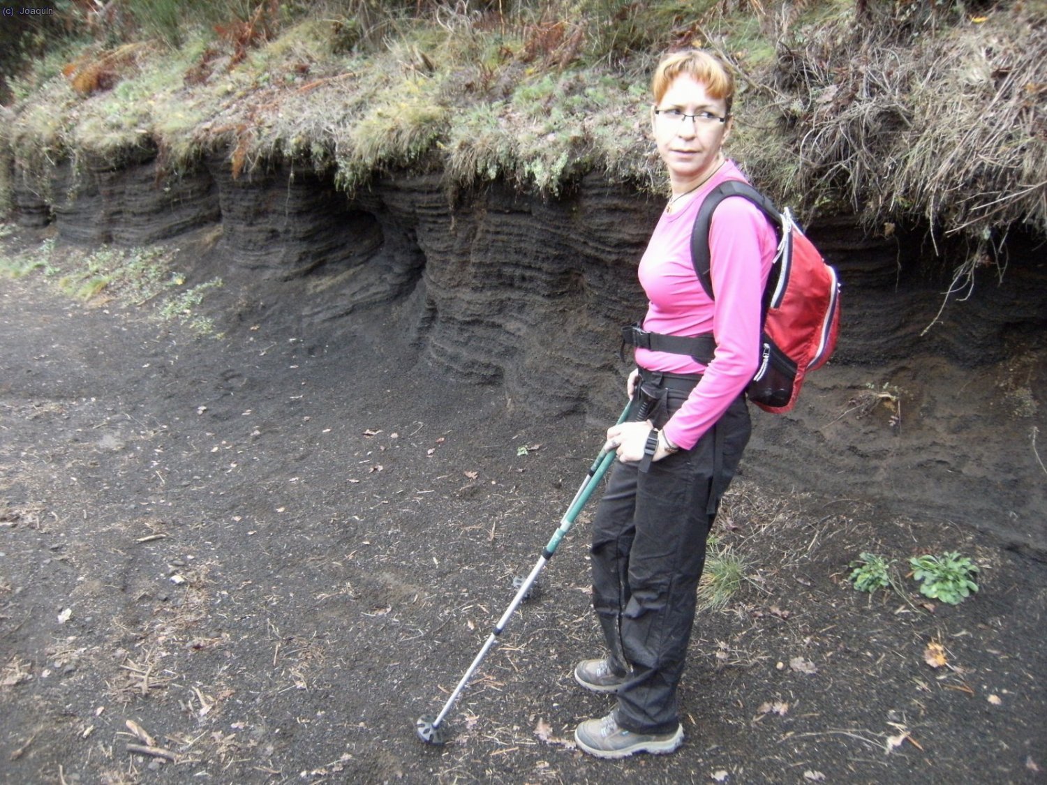 Anna en el camino de bajada a la Ermita de Santa Margarida. Observese las capas de ceniza negra volc&aacute;nica.