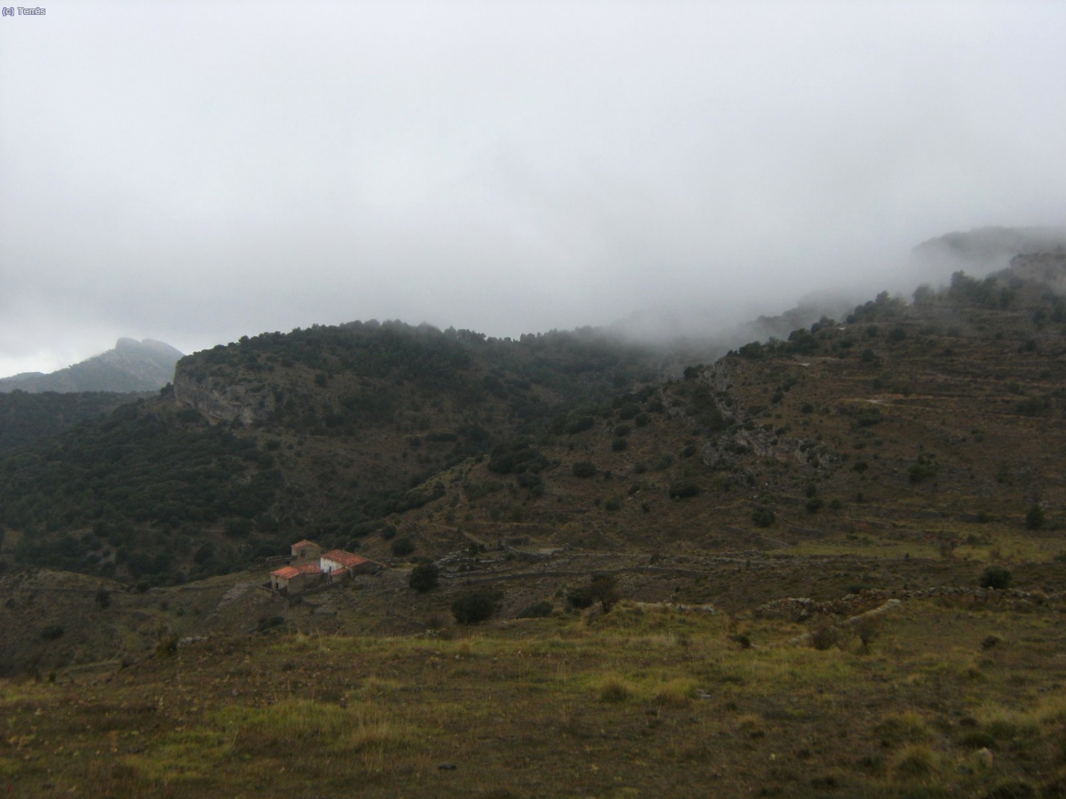 El Mas de Llach y las nubladas vertientes sur del Pe&ntilde;agolosa.