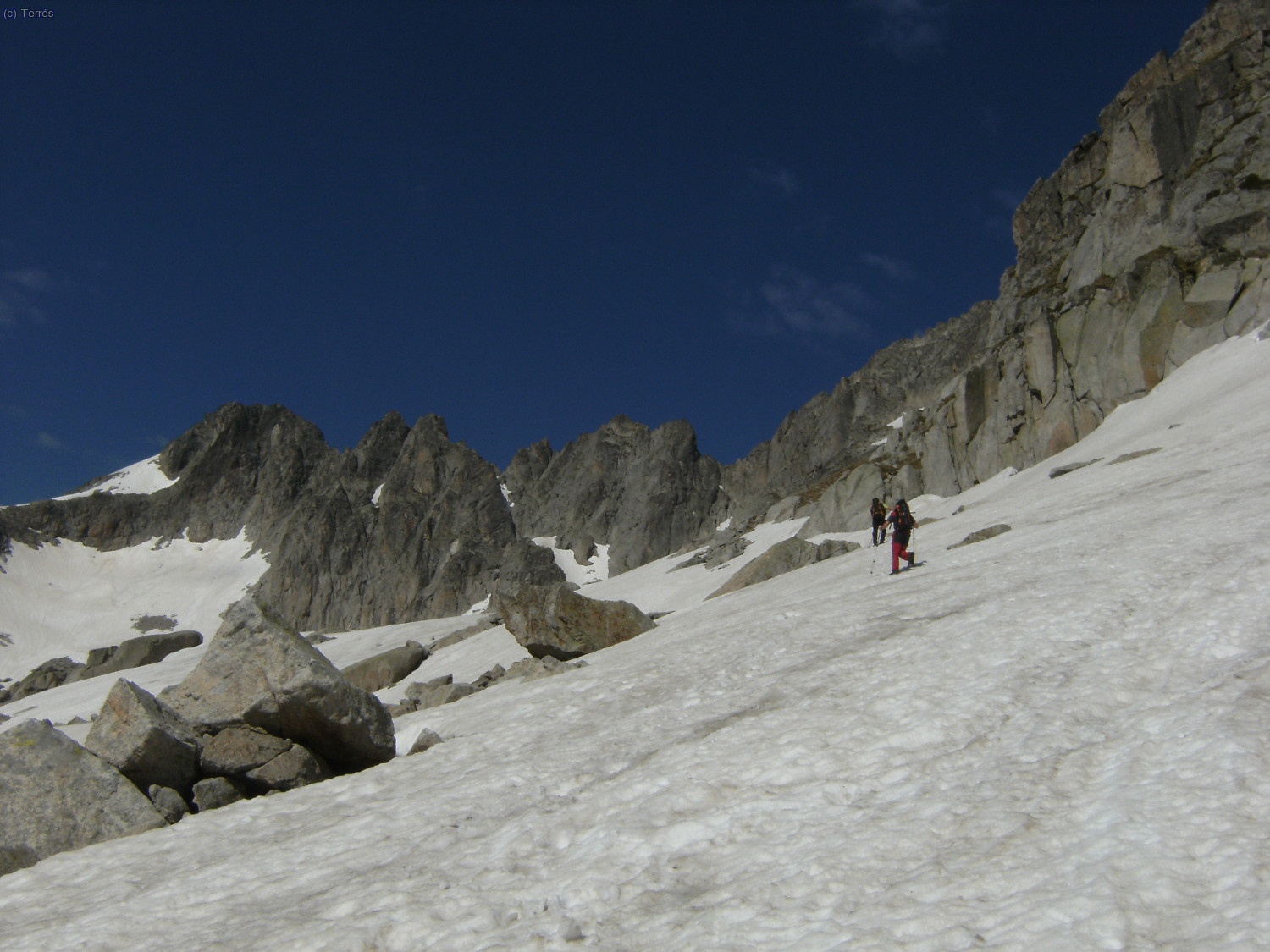 Subiendo por neveros de aproximaci&oacute;n a la pared este del Besiberri Norte. Al fondo la cresta de los Besiberris